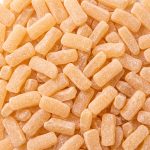 Pale orange herbal tablets scattered together.
